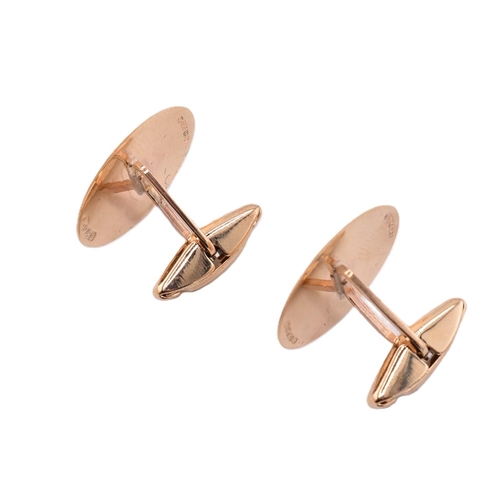 180 - A pair of hallmarked 9ct gold cufflinks. The cufflinks having oval faces framed by engined turned de... 