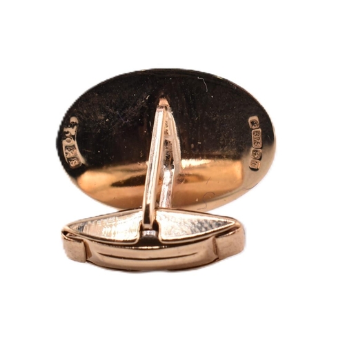 180 - A pair of hallmarked 9ct gold cufflinks. The cufflinks having oval faces framed by engined turned de... 