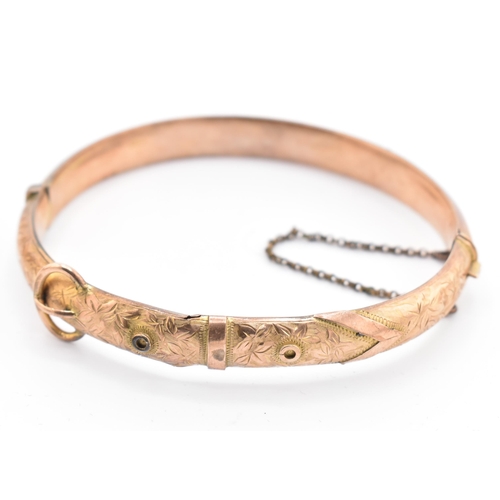 183 - An Edwardian hallmarked 9ct gold buckle bangle. The 9ct yellow gold hinged bangle having bright cut ... 