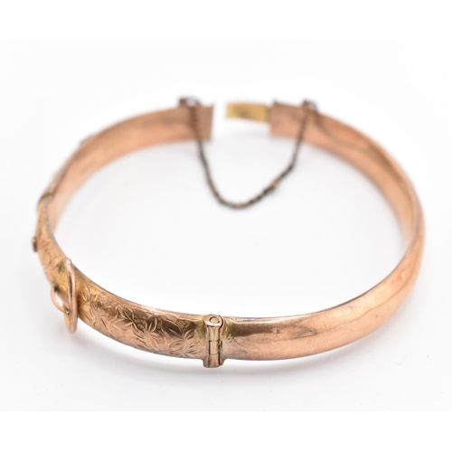 183 - An Edwardian hallmarked 9ct gold buckle bangle. The 9ct yellow gold hinged bangle having bright cut ... 