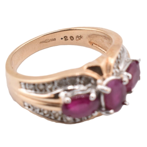 187 - A hallmarked 9ct gold ruby and diamond three stone ring. The ring set with three four claw set oval ... 