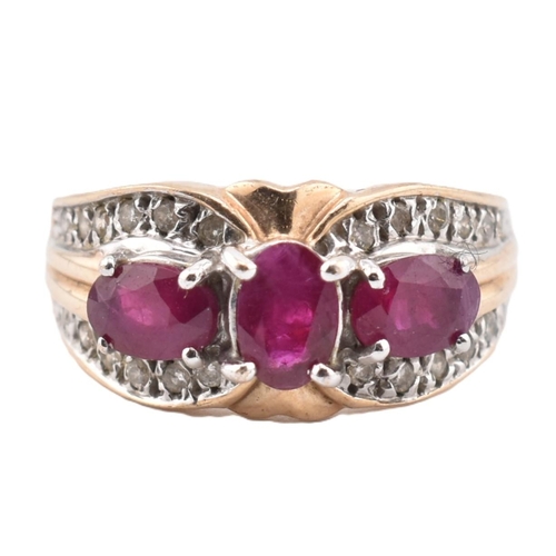 187 - A hallmarked 9ct gold ruby and diamond three stone ring. The ring set with three four claw set oval ... 