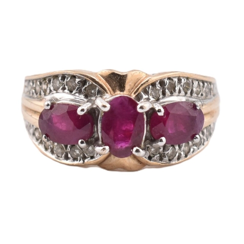 187 - A hallmarked 9ct gold ruby and diamond three stone ring. The ring set with three four claw set oval ... 