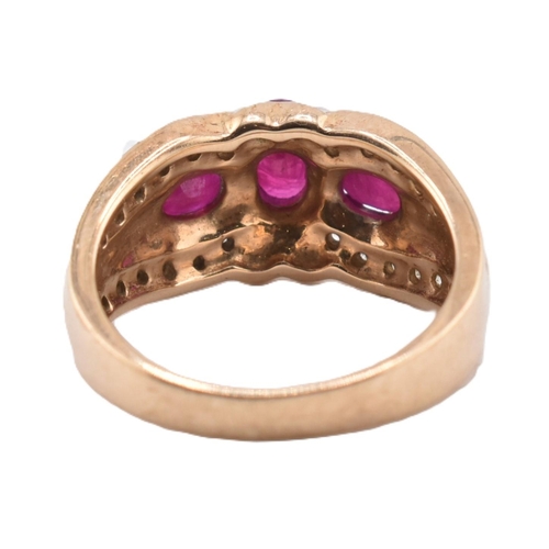 187 - A hallmarked 9ct gold ruby and diamond three stone ring. The ring set with three four claw set oval ... 