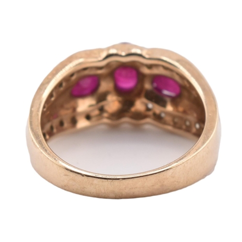 187 - A hallmarked 9ct gold ruby and diamond three stone ring. The ring set with three four claw set oval ... 