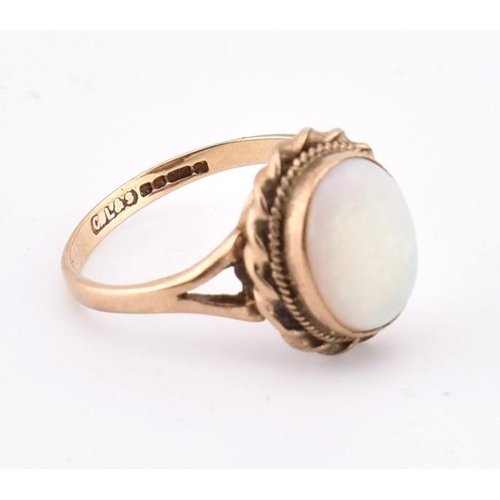 190 - A hallmarked 9ct gold and opal ring. The 9ct yellow gold ring set with a single bezel set oval opal ... 