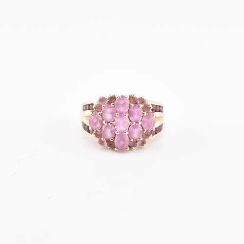 192 - A hallmarked 9ct gold pink sapphire and garnet cluster ring. The 9ct gold cluster ring set with nine... 