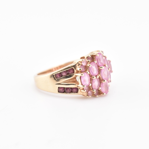 192 - A hallmarked 9ct gold pink sapphire and garnet cluster ring. The 9ct gold cluster ring set with nine... 