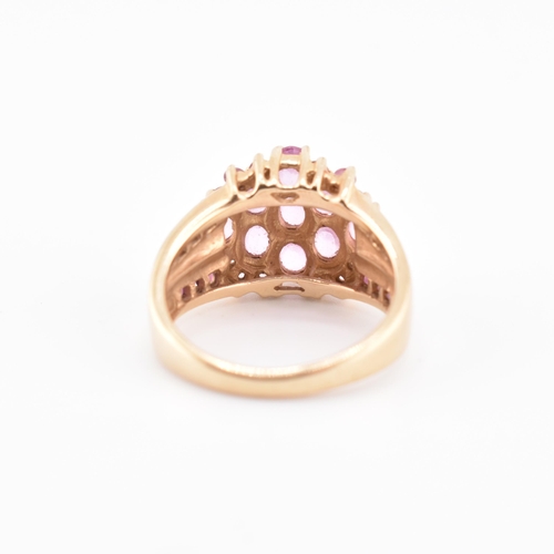 192 - A hallmarked 9ct gold pink sapphire and garnet cluster ring. The 9ct gold cluster ring set with nine... 