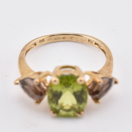 197 - A hallmarked 9ct gold changbai peridot and smoky quartz ring. The 9ct yellow gold ring set with a ce... 