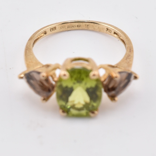 197 - A hallmarked 9ct gold changbai peridot and smoky quartz ring. The 9ct yellow gold ring set with a ce... 