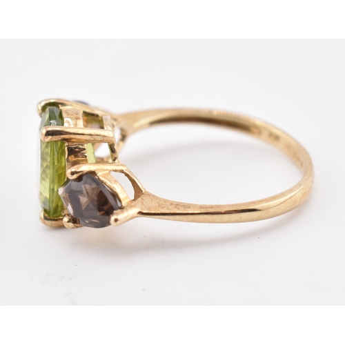 197 - A hallmarked 9ct gold changbai peridot and smoky quartz ring. The 9ct yellow gold ring set with a ce... 