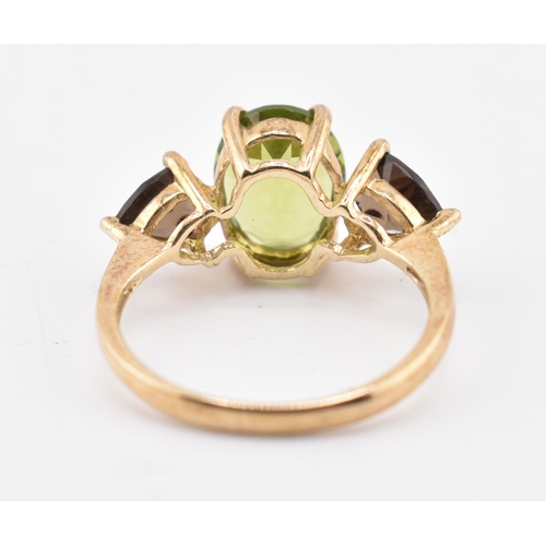 197 - A hallmarked 9ct gold changbai peridot and smoky quartz ring. The 9ct yellow gold ring set with a ce... 