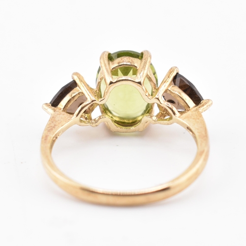 197 - A hallmarked 9ct gold changbai peridot and smoky quartz ring. The 9ct yellow gold ring set with a ce... 