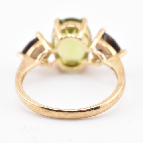 197 - A hallmarked 9ct gold changbai peridot and smoky quartz ring. The 9ct yellow gold ring set with a ce... 