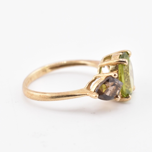 197 - A hallmarked 9ct gold changbai peridot and smoky quartz ring. The 9ct yellow gold ring set with a ce... 