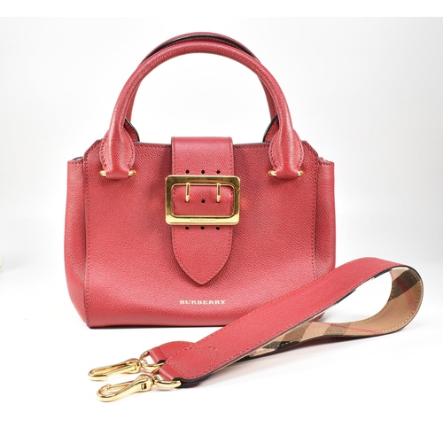 2 - A Burberry red buckle bag with crossbody strap. The Burberry 'The Buckle' bag having a red soft calf... 