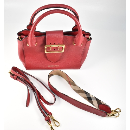 2 - A Burberry red buckle bag with crossbody strap. The Burberry 'The Buckle' bag having a red soft calf... 