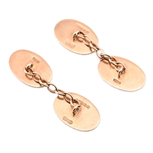 200 - A pair of hallmarked 9ct gold cufflinks. The 9ct yellow gold cufflinks having oval heads with engine... 