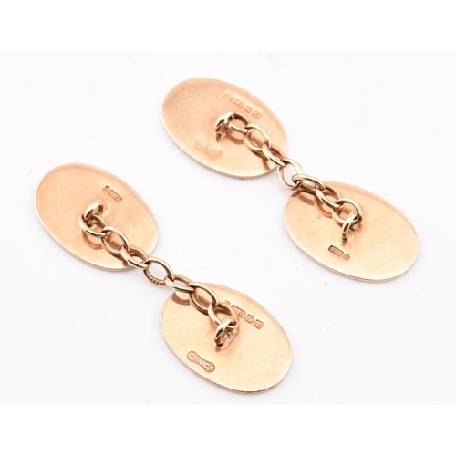 200 - A pair of hallmarked 9ct gold cufflinks. The 9ct yellow gold cufflinks having oval heads with engine... 