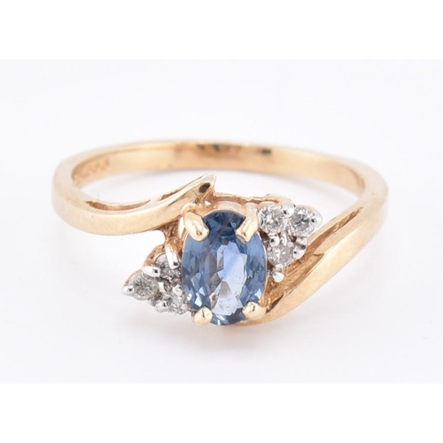 206 - A hallmarked 9ct gold sapphire and diamond crossover ring. The 9ct yellow gold ring set with a centr... 