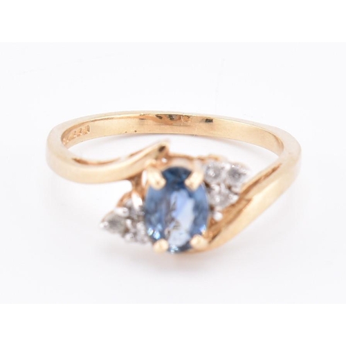 206 - A hallmarked 9ct gold sapphire and diamond crossover ring. The 9ct yellow gold ring set with a centr... 