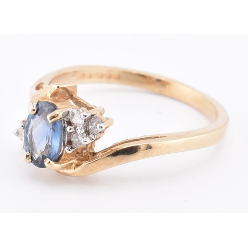 206 - A hallmarked 9ct gold sapphire and diamond crossover ring. The 9ct yellow gold ring set with a centr... 