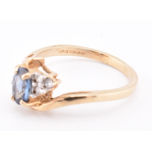 206 - A hallmarked 9ct gold sapphire and diamond crossover ring. The 9ct yellow gold ring set with a centr... 