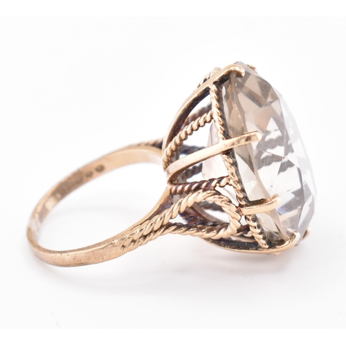 209 - A hallmarked 9ct gold and smoky quartz cocktail ring. The 9ct yellow gold ring having a single oval ... 