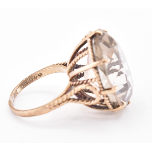 209 - A hallmarked 9ct gold and smoky quartz cocktail ring. The 9ct yellow gold ring having a single oval ... 