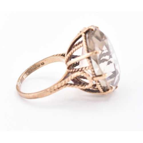 209 - A hallmarked 9ct gold and smoky quartz cocktail ring. The 9ct yellow gold ring having a single oval ... 