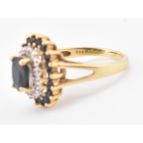 222 - A hallmarked 18ct gold sapphire and diamond cluster ring. The 18ct yellow gold ring having a central... 