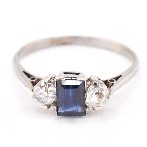 224 - An 18ct gold, platinum, sapphire and diamond three stone ring. The ring set with an emerald cut sapp... 