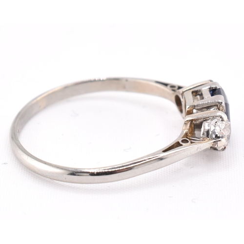 224 - An 18ct gold, platinum, sapphire and diamond three stone ring. The ring set with an emerald cut sapp... 