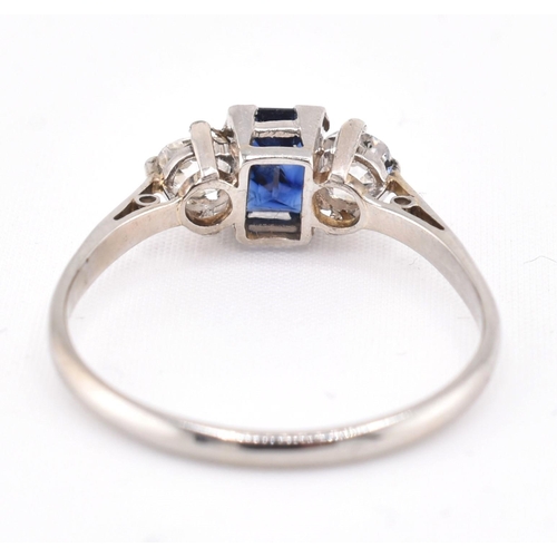 224 - An 18ct gold, platinum, sapphire and diamond three stone ring. The ring set with an emerald cut sapp... 