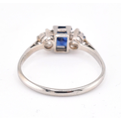 224 - An 18ct gold, platinum, sapphire and diamond three stone ring. The ring set with an emerald cut sapp... 