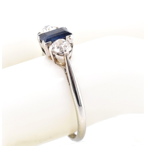 224 - An 18ct gold, platinum, sapphire and diamond three stone ring. The ring set with an emerald cut sapp... 