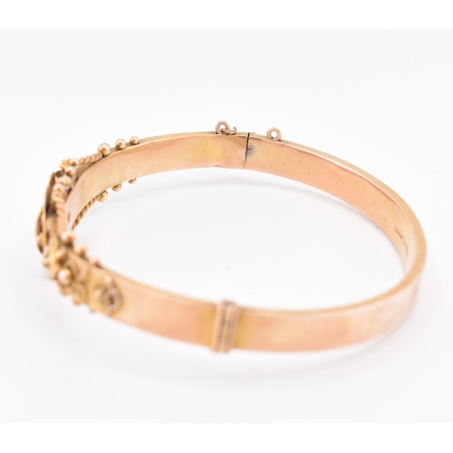 23 - An early 20th century hallmarked 9ct gold and diamond hinged bangle. The bangle set with a central o... 