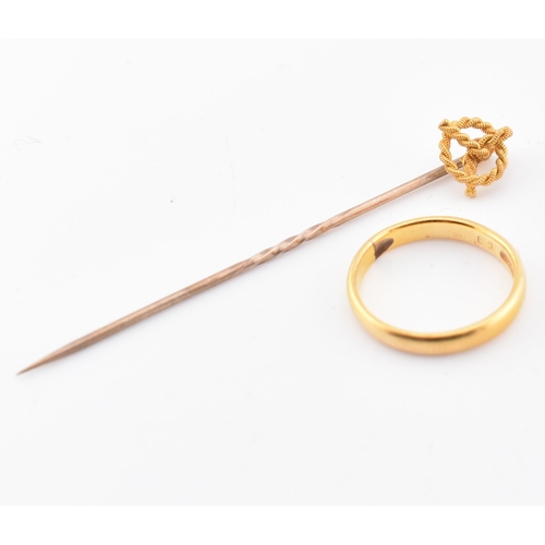 231 - A hallmarked 22ct gold band ring and a 15ct gold knot topped tie pin. The hallmarked 22ct yellow gol... 