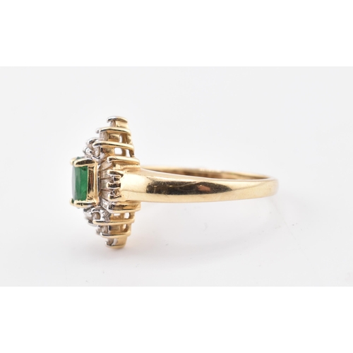 232 - A 14ct gold emerald and diamond halo cluster ring. The 14ct yellow gold ring set with a central oval... 