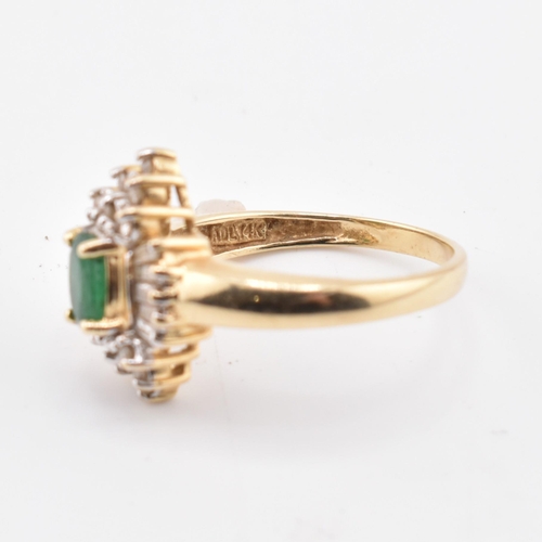 232 - A 14ct gold emerald and diamond halo cluster ring. The 14ct yellow gold ring set with a central oval... 