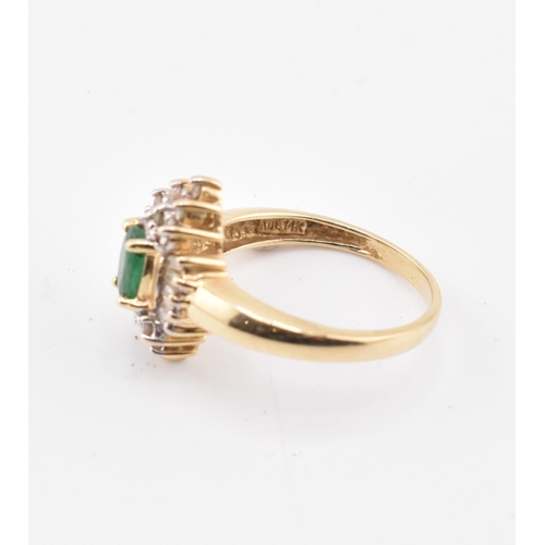 232 - A 14ct gold emerald and diamond halo cluster ring. The 14ct yellow gold ring set with a central oval... 