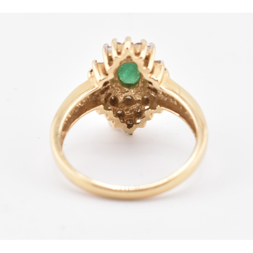 232 - A 14ct gold emerald and diamond halo cluster ring. The 14ct yellow gold ring set with a central oval... 