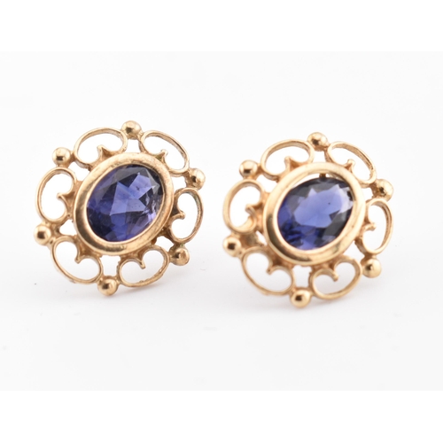 246 - A pair of 9ct gold and iolite stud earrings. The 9ct yellow gold earrings set each with a single bez... 