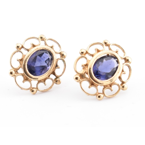 246 - A pair of 9ct gold and iolite stud earrings. The 9ct yellow gold earrings set each with a single bez... 