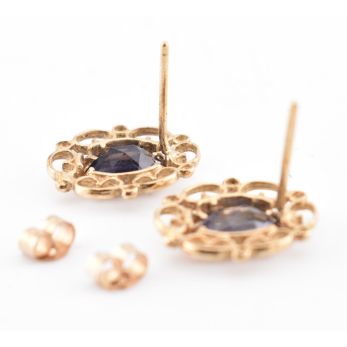 246 - A pair of 9ct gold and iolite stud earrings. The 9ct yellow gold earrings set each with a single bez... 