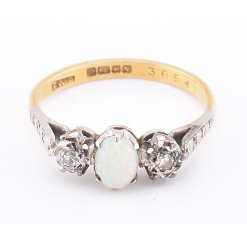 247 - A hallmarked 18ct gold opal and diamond three stone ring. The 18ct yellow gold ring set with a centr... 