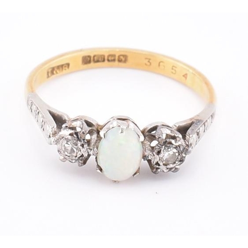 247 - A hallmarked 18ct gold opal and diamond three stone ring. The 18ct yellow gold ring set with a centr... 