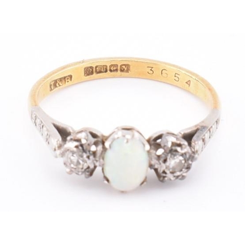 247 - A hallmarked 18ct gold opal and diamond three stone ring. The 18ct yellow gold ring set with a centr... 