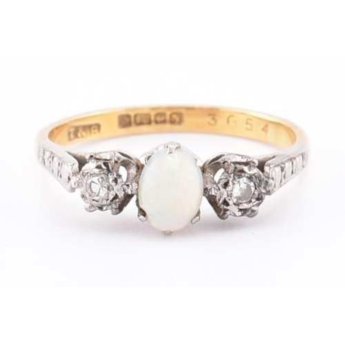 247 - A hallmarked 18ct gold opal and diamond three stone ring. The 18ct yellow gold ring set with a centr... 